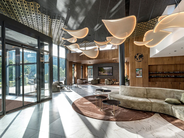 Ein exklusives Möbeldesign in der Hotellobby des Spa-Hotels Mooshof bietet Komfort und Stil.