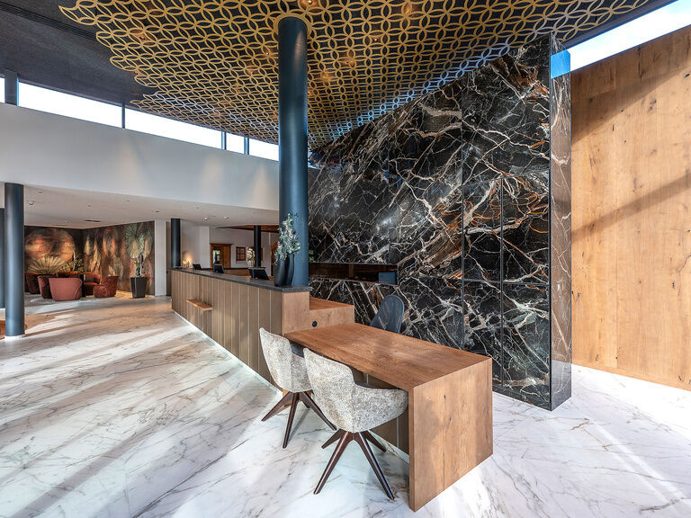 Die Marmorwand hinter der Rezeption bietet den Gästen schon beim einchecken ein luxuriöses Gefühl.